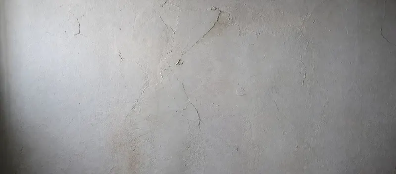 Rissige, strukturierte Wandputzoberfläche in einem Schweizer Altbau vor der Sanierung