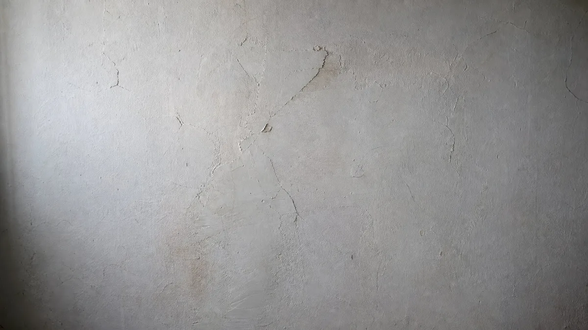 Rissige, strukturierte Wandputzoberfläche in einem Schweizer Altbau vor der Sanierung