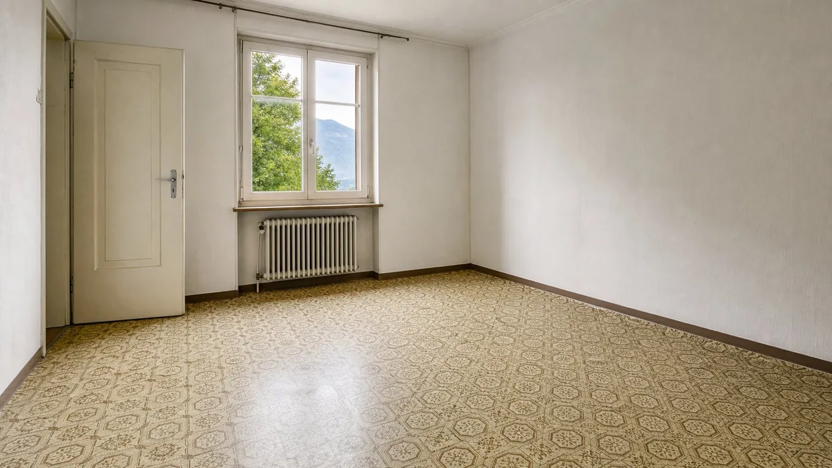 Leeres Zimmer einer älteren Schweizer Mietwohnung mit gemustertem Novilon-Bodenbelag