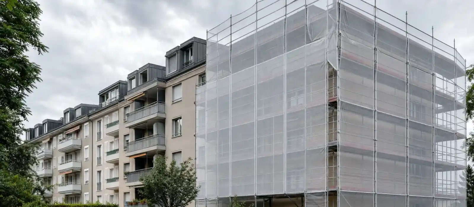 Fassade eines Schweizer Wohngebaeudes waehrend einer fachgerechten Sanierung